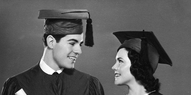 A young man and a young woman wear the cap and gown outfit that symbolizes the college graduate in North America, mid 20th Ce