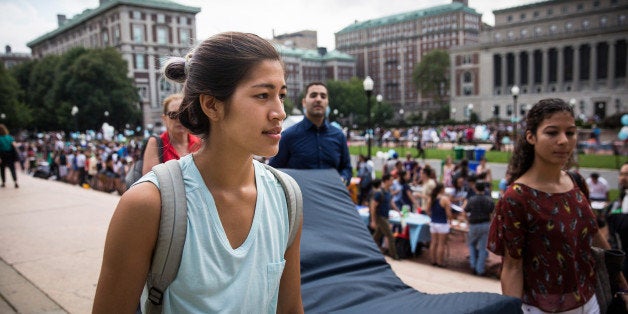 NEW YORK, NY - SEPTEMBER 05: Emma Sulkowicz (L), a senior visual arts student at Columbia University, carries a mattress, with the help of three strangers who met her moments before, in protest of the university's lack of action after she reported being raped during her sophomore year on September 5, 2014 in New York City. Sulkowicz has said she is committed to carrying the mattress everywhere she goes until the university expels the rapist or he leaves. The protest is also doubling as her senior thesis project. (Photo by Andrew Burton/Getty Images)