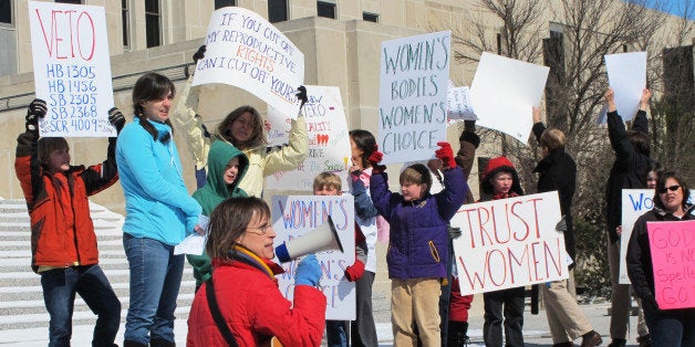 FILE - In this March 25, 2013, file photo Kris Kitko, left, leads chants of protest at an abortion-rights rally at the state Capitol in Bismarck, N.D. Abortion-rights advocates filed a lawsuit in federal court Tuesday, June 25, 2013, in Bismarck, N.D., challenging two new North Dakota laws that impose the nation's toughest abortion restrictions. (AP Photo/James MacPherson, File)