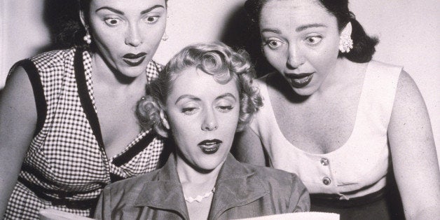 Three women (Claire Barry, Beverly Lawrence and Merna Barry) react with shock as they read a newspaper review about the Kinse