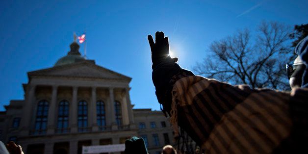 Malika Daniel, of Fairburn, Ga., raises her hand during a prayer song at the March For Life anti-abortion rally outside the State Capitol, Wednesday, Jan. 22, 2014, in Atlanta. Hundreds of anti-abortion demonstrators gathered outside the Statehouse for the annual rally to protest the Supreme Court's landmark 1973 decision that declared a constitutional right to abortion. (AP Photo/David Goldman)