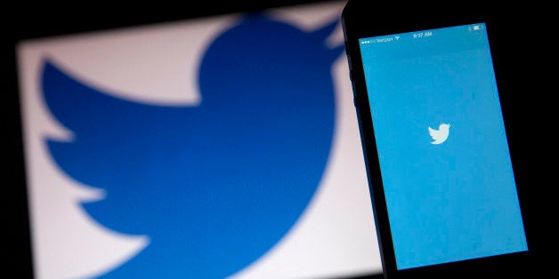The Twitter Inc. application and logo are displayed on a laptop computer and Apple Inc. iPhone 5s in this arranged photograph