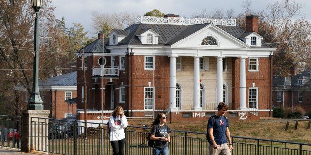 University of Virginia students walk to campus past the Phi Kappa Psi fraternity house at the University of Virginia in Charlottesville, Va., Monday, Nov. 24, 2014. The university has suspended activities at all campus fraternal organizations amid an investigation into a published report in which a student described being sexually assaulted by seven men in 2012 at the Phi Kappa Psi house. (AP Photo/Steve Helber)
