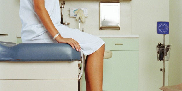 Young woman on table in doctor's office, mid section