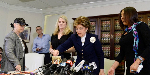 LOS ANGELES, CA - JANUARY 07: Three alleged victims of sexual abuse by comedian Bill Cosby using the assumed name Lynn Neal (L) Linda Kirkpatrick (2nd L) and using the assumed name Kacey (R) look on as attorney Gloria Allred (C) displays a photograph of Linda Kirkpatrick with the comedian at a tennis event during a news conference January 7, 2015 in Los Angeles, California. Cosby has been accused of sexual assault by over 20 women. (Photo by Kevork Djansezian/Getty Images)