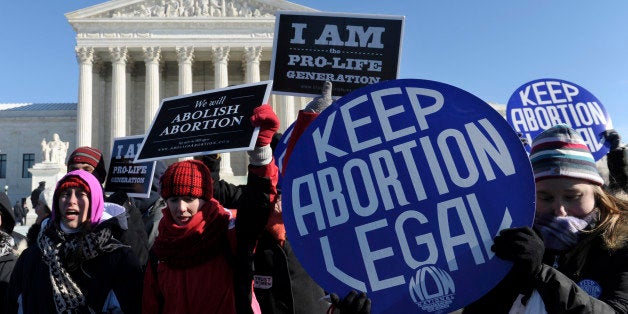 Pro-abortion and anti-abortion protestors rally outside the Supreme Court in Washington, Wednesday, Jan. 22, 2014. Thousands of abortion opponents are facing wind chills in the single digits to rally and march on Capitol Hill to protest legalized abortion, with a signal of support from Pope Francis. (AP Photo/Susan Walsh)