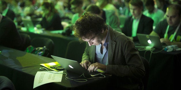 An attendee takes notes on an Apple Inc. laptop computer while attending a panel session at the Disrupt Europe 2014 conferenc