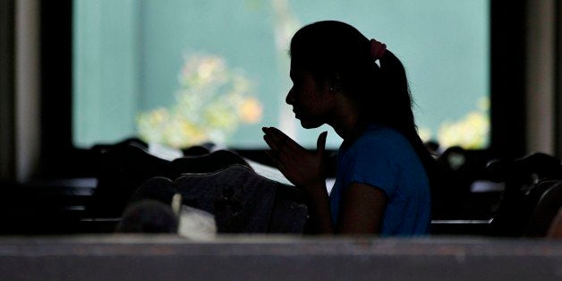 A Sri Lankan Catholic devotee prays at a church in Colombo, Sri Lanka, Wednesday, Dec. 31, 2014. Pope Francis is scheduled to begin a three-day visit on Jan. 13, five days after the countryâs presidential elections. (AP Photo/Eranga Jayawardena)