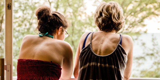 Mother and daughter conversing on balcony.