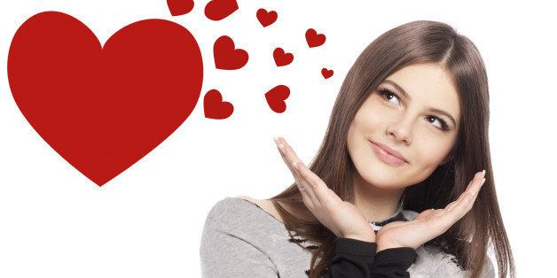 Valentines Day. Beautiful girl teenager with Valentines Day heart sign glossy hair with copy space closeup in studio on white background