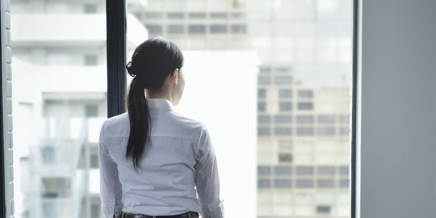 Businesswoman looking out window in empty office