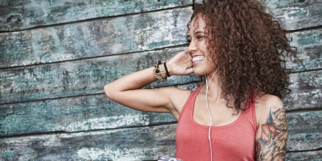 Woman listening to mp3 player on city street