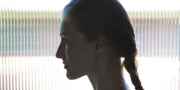 SILHOUETTE OF WOMAN AGAINST WINDOW