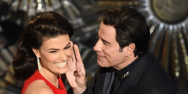 John Travolta (R) and Idina Menzel present an award on stage at the 87th Oscars February 22, 2015 in Hollywood, California. A