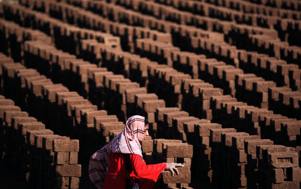A Pakistani woman arranges bricks as she works at a brick factory on the outskirts of Islamabad, Pakistan, Monday, March 8, 2