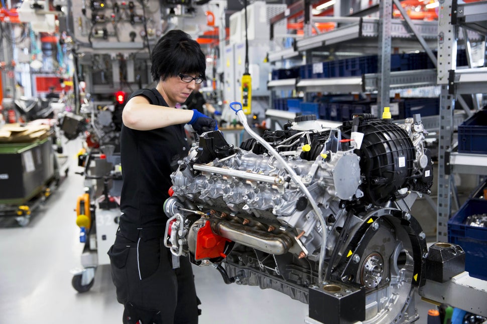 A female engineer hand-builds a M157 5.5L V8 bi-turbo engine at the Mercedes-AMG engine production factory in Affalterbach, G