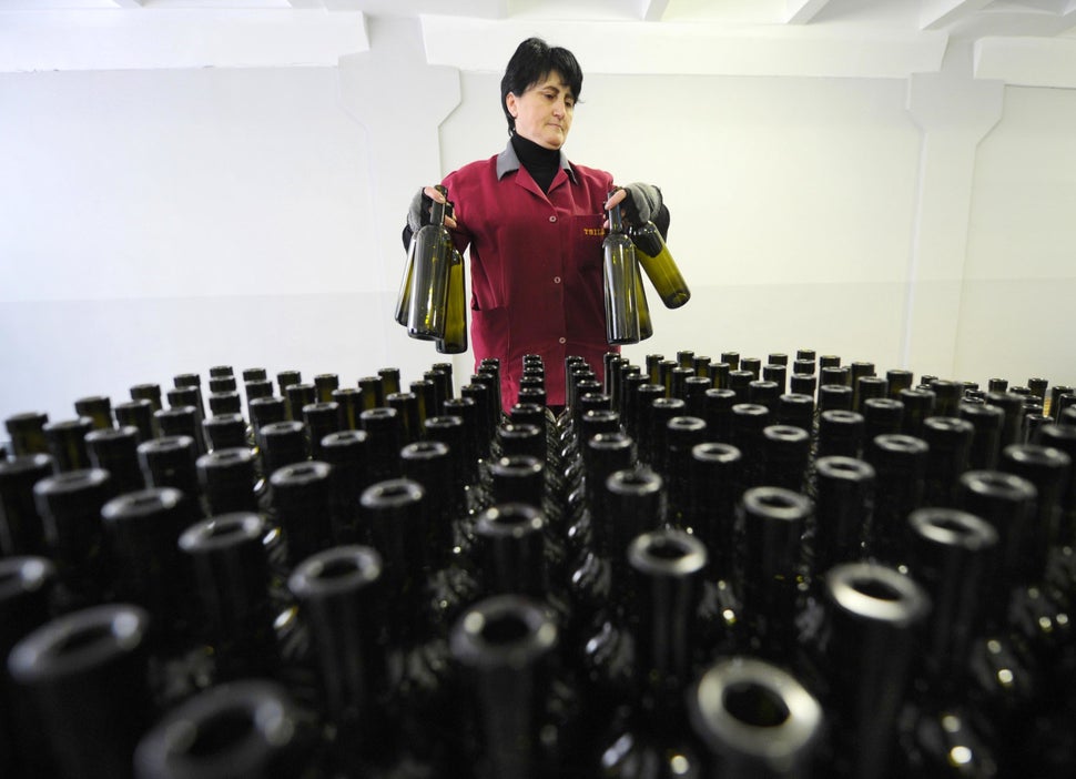 An employee stands in front of bottles at a winery in Tbilisi on Feb. 11, 2013.  (VANO SHLAMOV/AFP/Getty Images)