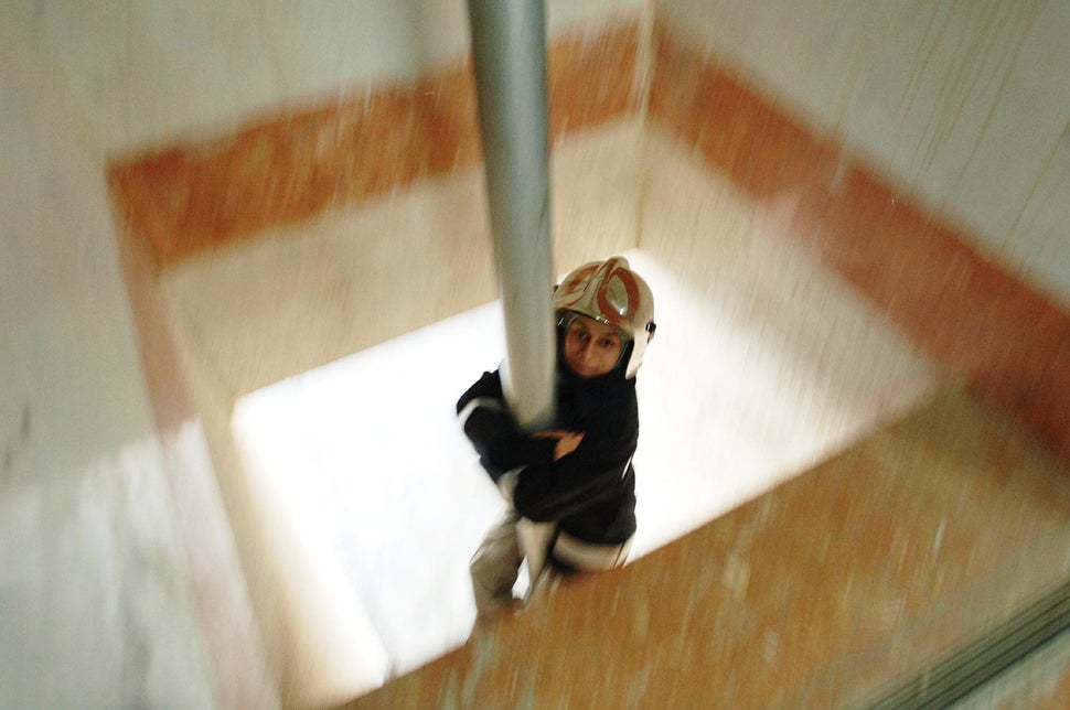 Mahboubeh Khoshsolat, one of the only women's fire and rescue units in the Middle East, slides down the fire pole at Fire Sta