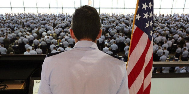 A junior officer reads the names of U.S. troops recently killed in action to cadets standing at attention before the start of lunch on the Air Force Academy campus, near Colorado Springs, Colo., Wednesday Aug. 13, 2014. Air Force Academy leaders are asking coaches to take a bigger role in preventing sexual assaults by talking with athletes about the issue. Commanders also said Wednesday they expect an upcoming review of the athletic department to show whether it has a "negative culture," a term the service often uses to describe an atmosphere conducive to sexual abuse. (AP Photo/Brennan Linsley)