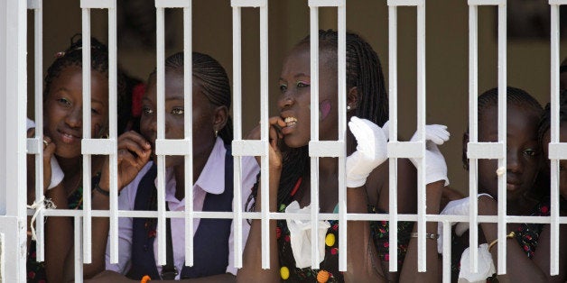 School girls look watch first lady Michelle Obama and Senegal's first lady Madame Marieme Faye Sall during a visit to the all-girls Martin Luther King Middle School, Thursday, June 27, 2013 in Dakar Senegal. (AP Photo/Carolyn Kaster)