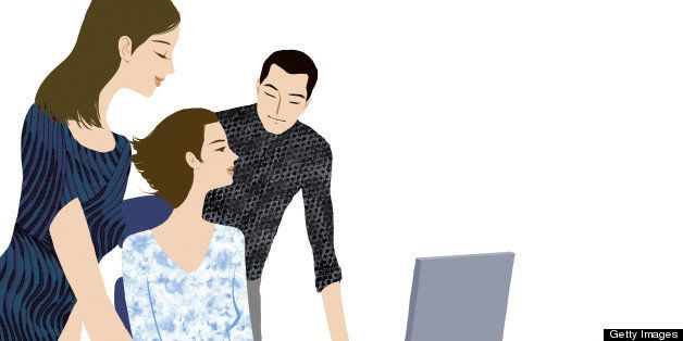 Two people helping a woman at a computer