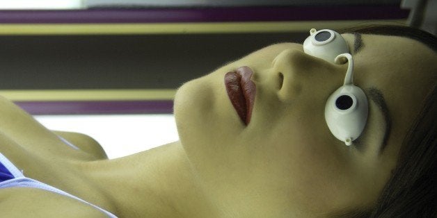 A young woman lying in a tanning capsule