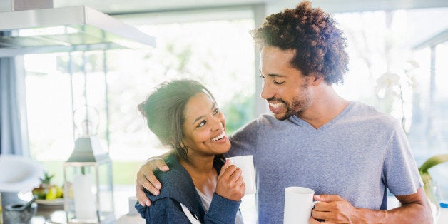 Smiling couple embracing in the kitchen in the morning