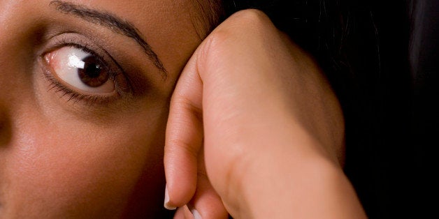 Close-up of a young woman resting her head on her hand