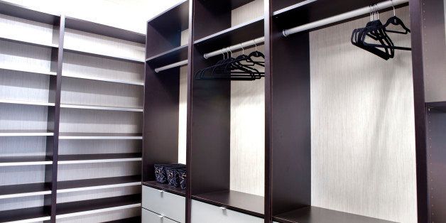 Large walk-in closet with empty shelves and draws