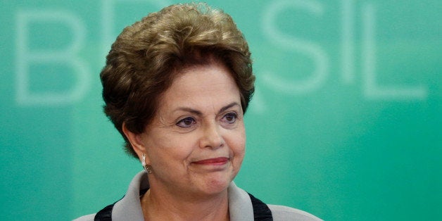 Brazil's President Dilma Rousseff smiles as she arrives for a government ceremony at the Planalto presidential palace in Brasilia, Brazil, Monday, March 16, 2015. Massive protests calling for Rousseff's impeachment on Sunday have narrowed her options to fend off political and economic crises, but her ouster remains highly unlikely, analysts said Monday. (AP Photo/Eraldo Peres)