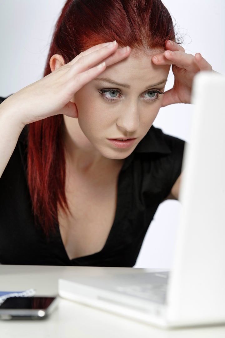 Professional woman showing concern at work using her laptop
