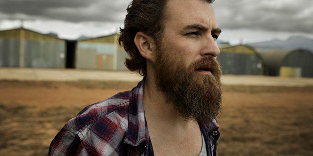 Serious man with full beard in abandoned landscape