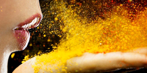 close up of a mouth blowing on yellow dust