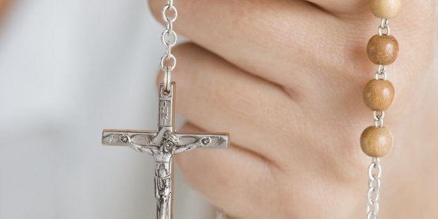 Hand holding rosary beads