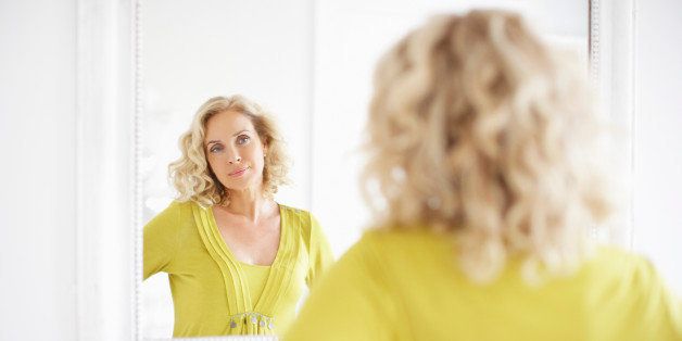 Mature woman looking in mirror