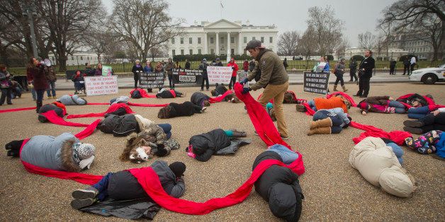 CORRECTS TO ANTI-ABORTION ACTIVISTS - Anti-abortion rights activists are connected with a red piece of cloth as they stage a 'die-in' in front of the White House in Washington, Wednesday, Jan. 21, 2015. Tomorrow marks the 42nd anniversary of the landmark 1973 Roe vs Wade decision and the March for Life, an annual gathering of abortion protest that dates back to 1974. (AP Photo/Pablo Martinez Monsivais)