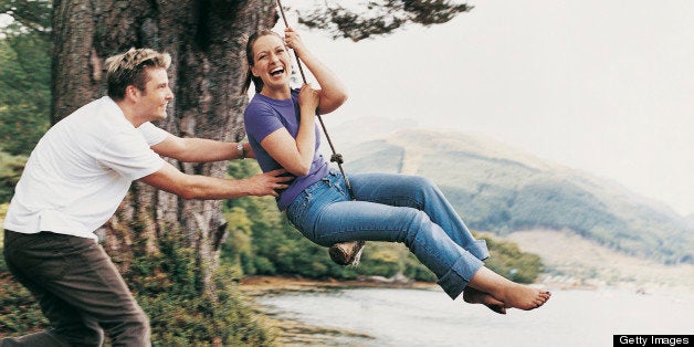 Couple Playing on a Rope Swing, Man Pulling Woman