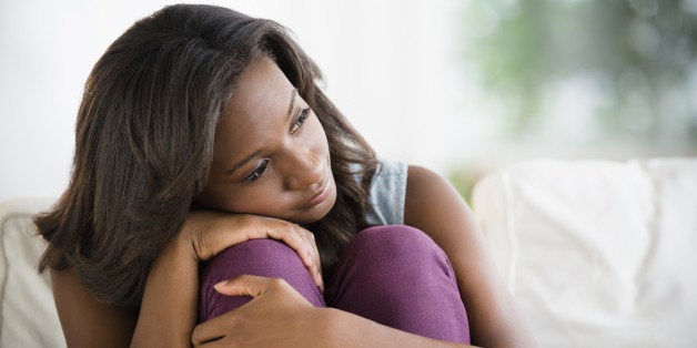 Black woman hugging her knees