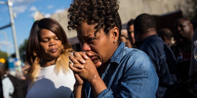 BALTIMORE, MD - APRIL 28: A woman cries after being prayed over during a protest near the CVS pharmacy that was set on fire