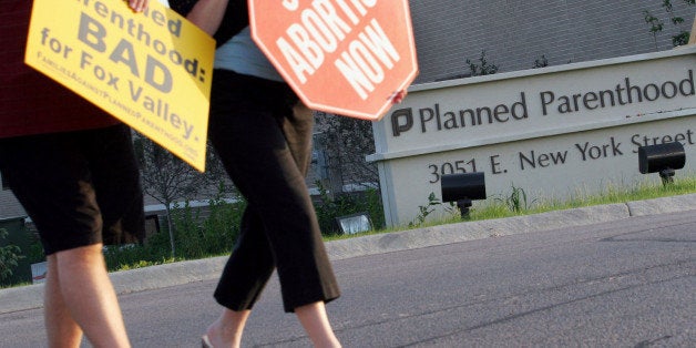 FILE - In this Sept. 18, 2007 file photo, protesters march near a Planned Parenthood location in Aurora, Ill. Some Illinois lawmakers are seeking to require annual inspections for all the state's abortion clinics, more than three years after officials took steps to reinforce the system following a report by The Associated Press that some facilities had gone 15 years without an inspection. (AP Photo/Stacie Freudenberg, File)