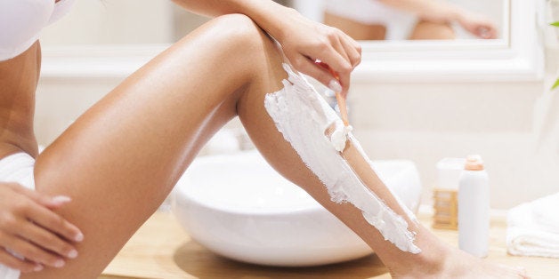 close up of woman shaving legs...