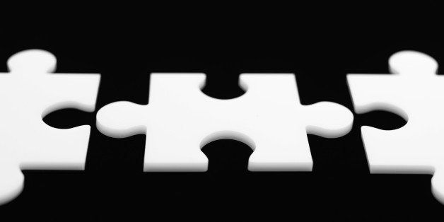 Three separated jigsaw puzzle pieces in a line.