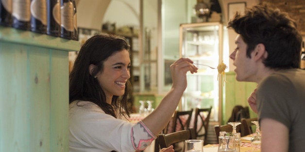 happy young couple eating together in restaurant