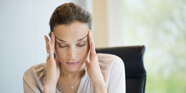 Close-up of a businesswoman suffering from a headache in an office