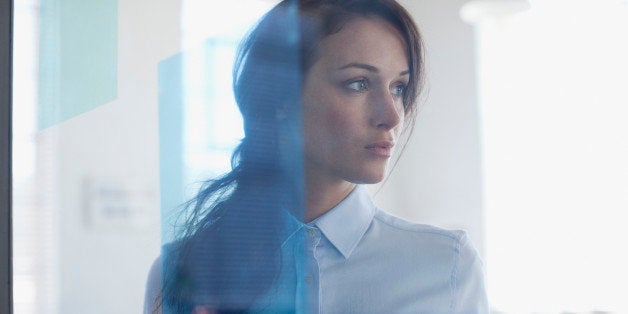 Pensive businesswoman in office window