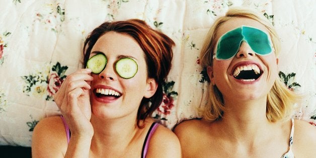 Two Female Teenagers Lying in Bed Wearing Eye Masks