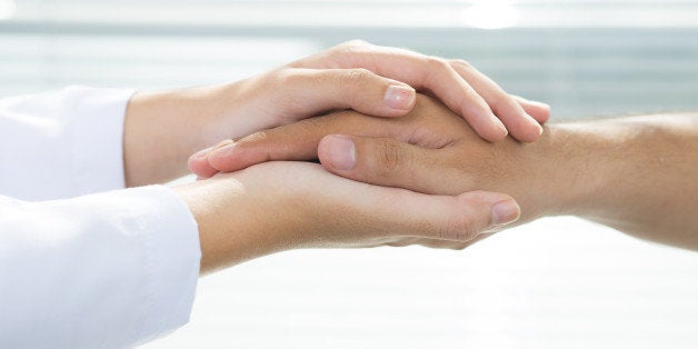 Two people holding hands for comfort