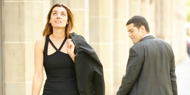 Businessman staring at woman walking on sidewalk