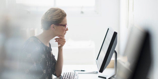 USA, New Jersey, Side view of business woman working on desktop pc in office