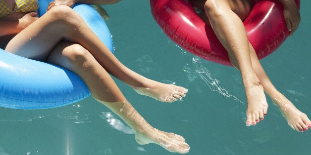 Girls sitting in inflatable rings in swimming pool